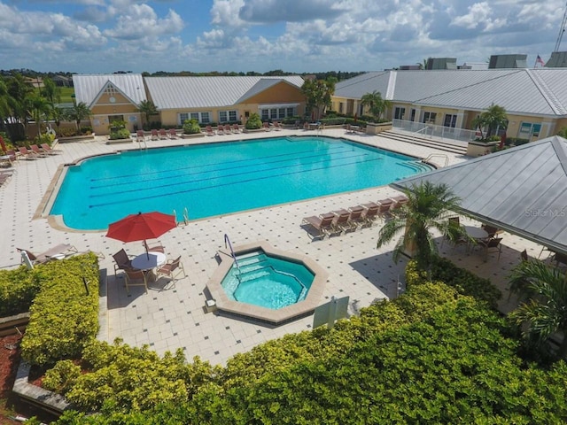 view of swimming pool with a community hot tub and a patio area