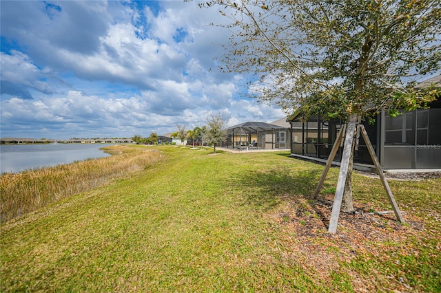 view of yard with a lanai and a water view