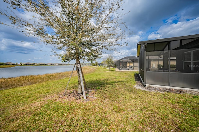 view of yard featuring a lanai and a water view