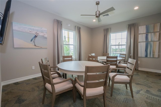 dining space with dark colored carpet, a wealth of natural light, and ceiling fan