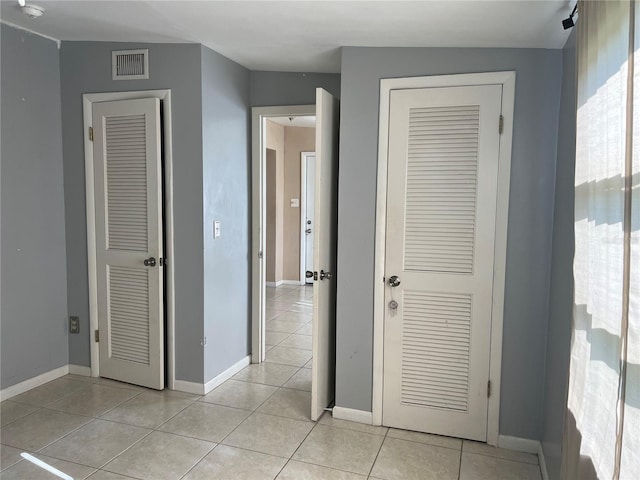 hall with light tile patterned floors and lofted ceiling