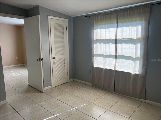 unfurnished bedroom featuring a closet and light tile patterned flooring