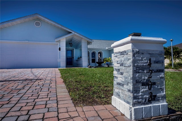 view of front of home with a garage and a front lawn