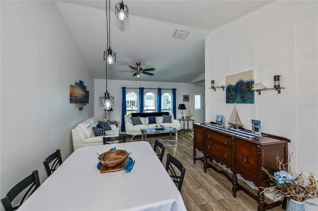 dining space with ceiling fan, light hardwood / wood-style floors, and lofted ceiling