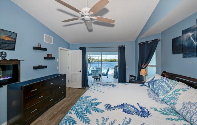 bedroom with hardwood / wood-style floors, lofted ceiling, access to outside, a water view, and ceiling fan