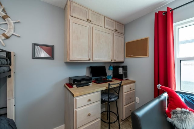 office space with hardwood / wood-style flooring, a healthy amount of sunlight, and built in desk