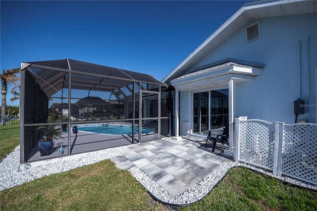 view of swimming pool with glass enclosure and a patio area