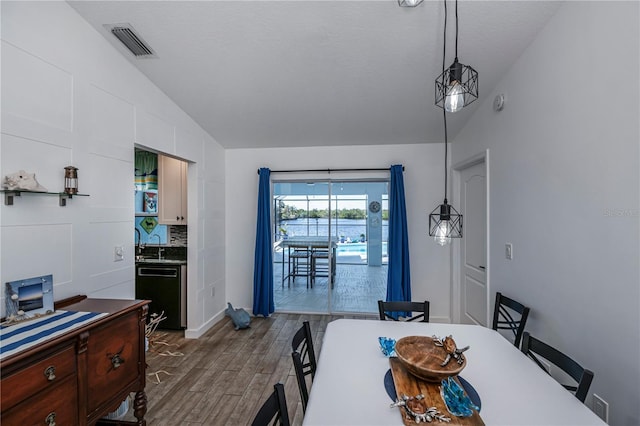 dining area with lofted ceiling, dark wood-style flooring, and visible vents