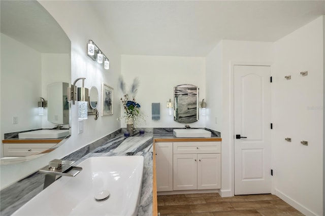 full bath featuring wood tiled floor, vanity, and baseboards