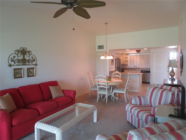 living room featuring ceiling fan with notable chandelier, light colored carpet, and sink