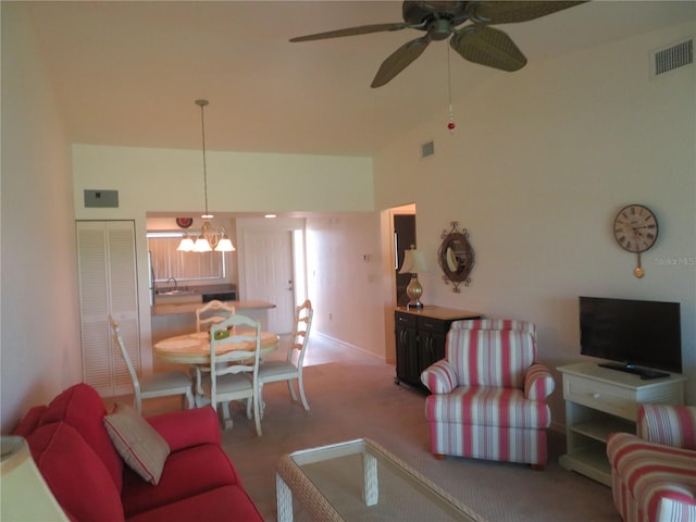 living room with carpet flooring, a high ceiling, ceiling fan with notable chandelier, and sink