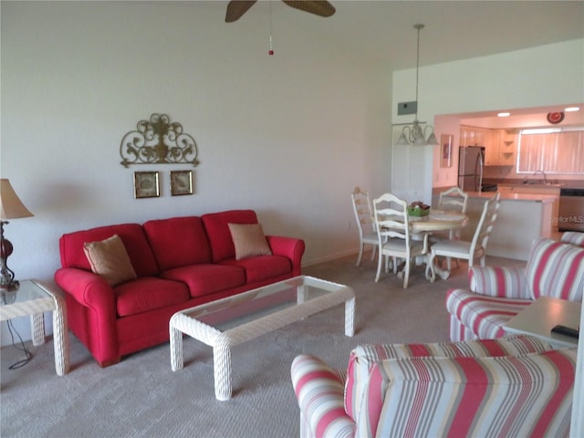 carpeted living room featuring ceiling fan and sink