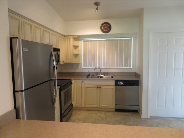 1360 Rio De Janeiro Ave Unit 117, Punta Gorda, FL 33983 - kitchen with appliances with stainless steel finishes, cream cabinets, a sink, and light tile patterned flooring
