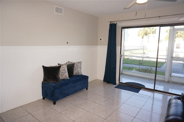 living area featuring light tile patterned floors and ceiling fan