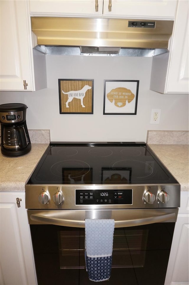 kitchen featuring white cabinetry and electric stove