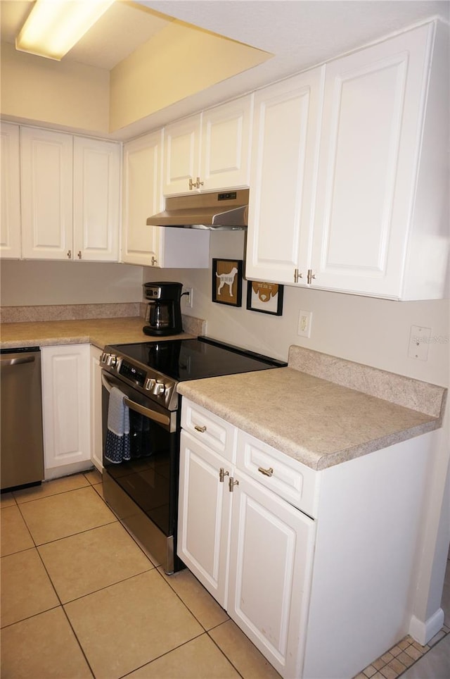 kitchen with light tile patterned floors, stainless steel appliances, and white cabinetry