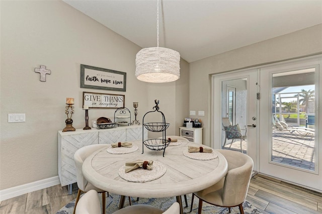 dining space featuring lofted ceiling and light wood-type flooring