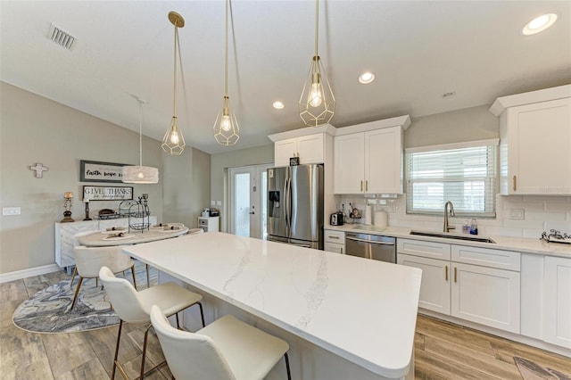 kitchen with a kitchen island, white cabinetry, and appliances with stainless steel finishes