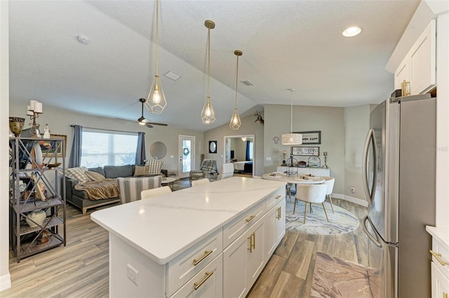 kitchen featuring stainless steel fridge, white cabinets, and light hardwood / wood-style floors