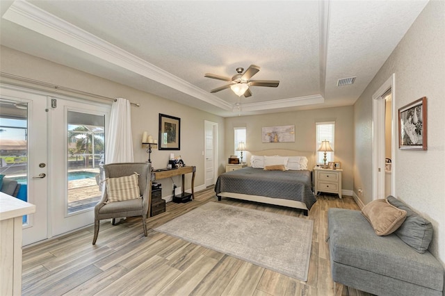 bedroom featuring access to exterior, ceiling fan, light hardwood / wood-style flooring, and multiple windows