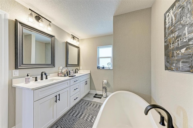 bathroom featuring vanity, a textured ceiling, a bathing tub, and tile patterned flooring