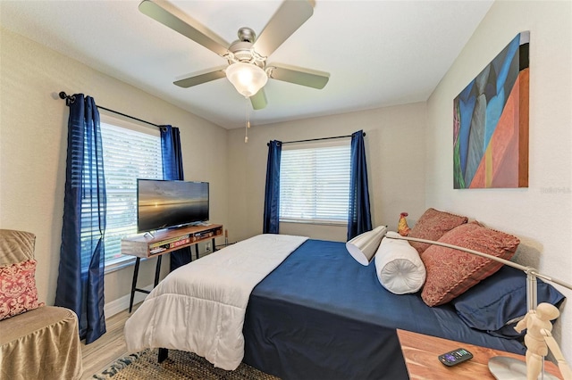 bedroom with hardwood / wood-style floors, multiple windows, and ceiling fan