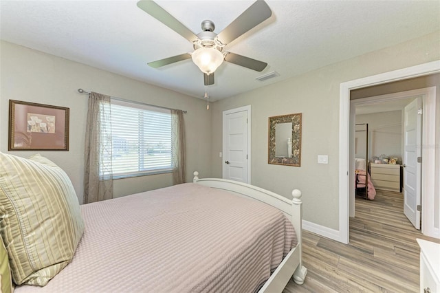 bedroom with ceiling fan and light hardwood / wood-style flooring