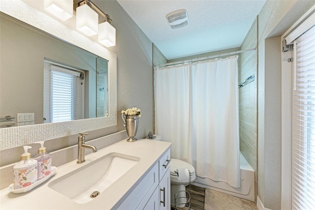 full bathroom with vanity, toilet, shower / bathtub combination with curtain, and a textured ceiling