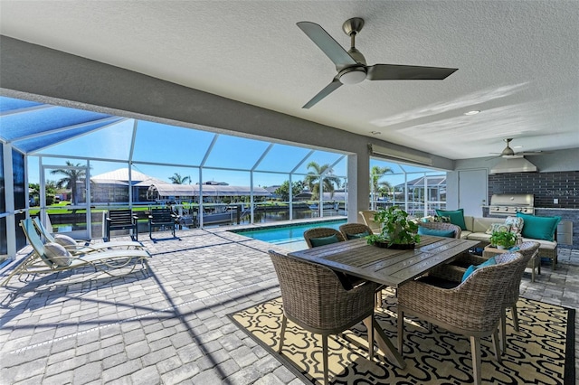 view of patio / terrace featuring an outdoor kitchen, ceiling fan, glass enclosure, and grilling area