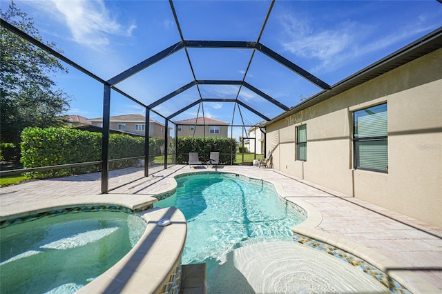 view of swimming pool featuring a patio, an in ground hot tub, and glass enclosure