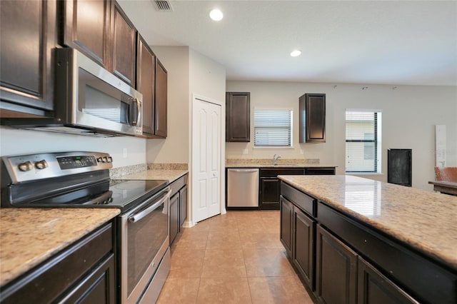 kitchen featuring dark brown cabinetry, stainless steel appliances, sink, and light tile patterned floors