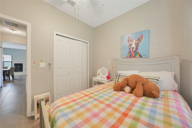 bedroom with tile patterned flooring, ceiling fan, and a closet