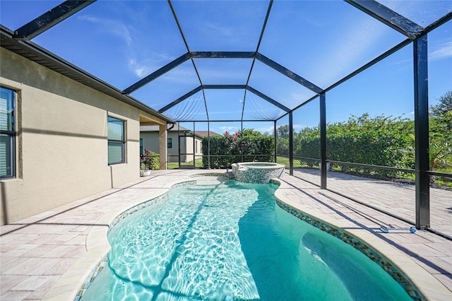 view of pool with an in ground hot tub, a patio area, and glass enclosure