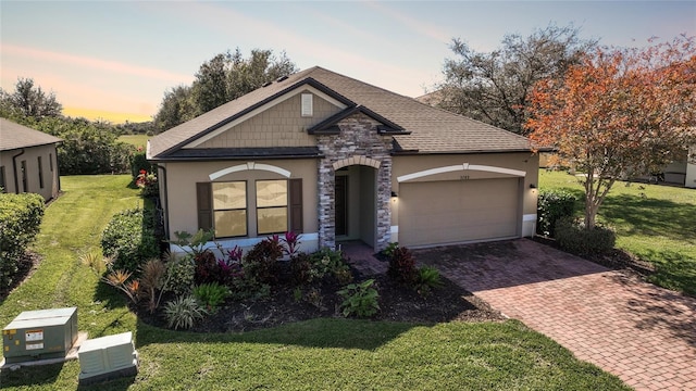 view of front of house featuring a garage and a lawn