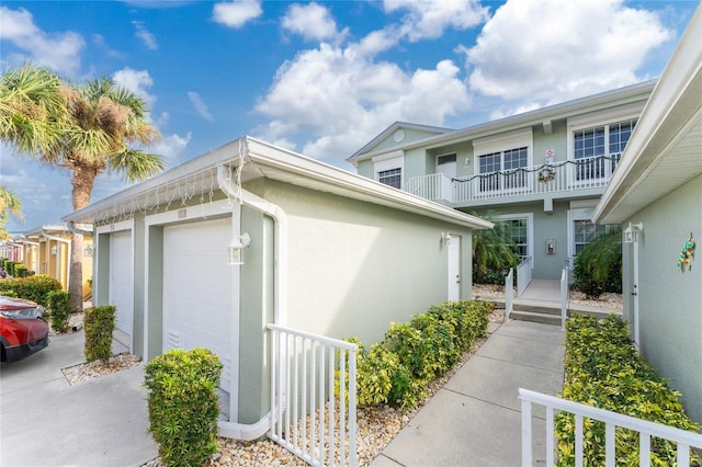 view of side of property featuring a garage and a balcony