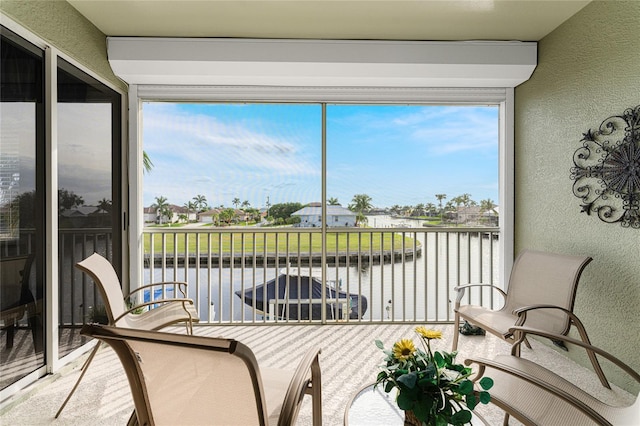 sunroom featuring a water view