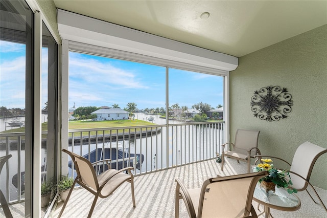 sunroom / solarium with a water view and plenty of natural light