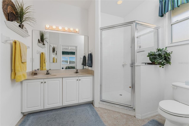 bathroom featuring tile patterned floors, a shower with door, vanity, and toilet