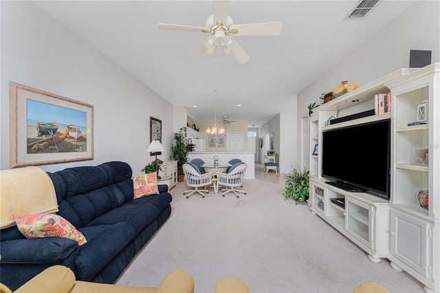 living room featuring light carpet and ceiling fan with notable chandelier