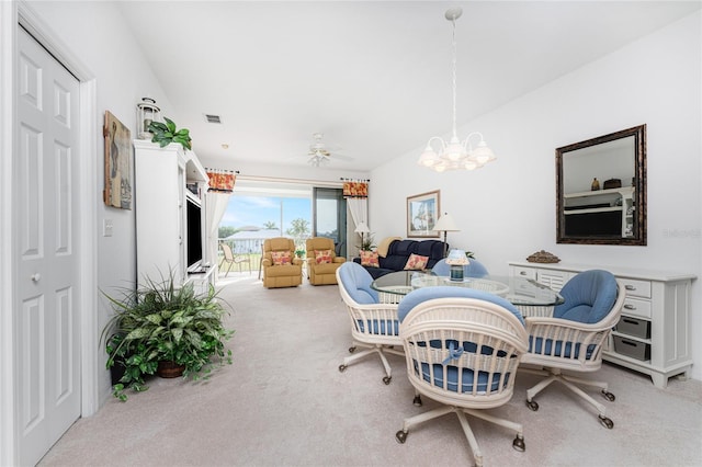 dining space featuring carpet flooring and ceiling fan with notable chandelier