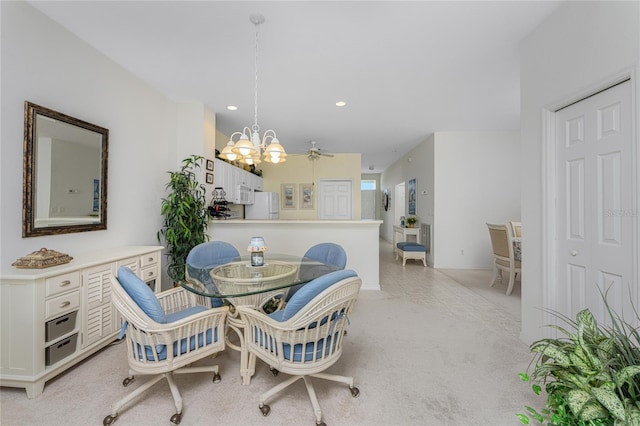 carpeted dining area featuring ceiling fan with notable chandelier