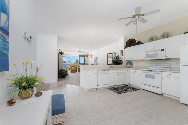 kitchen featuring kitchen peninsula, white appliances, ceiling fan with notable chandelier, pendant lighting, and white cabinetry