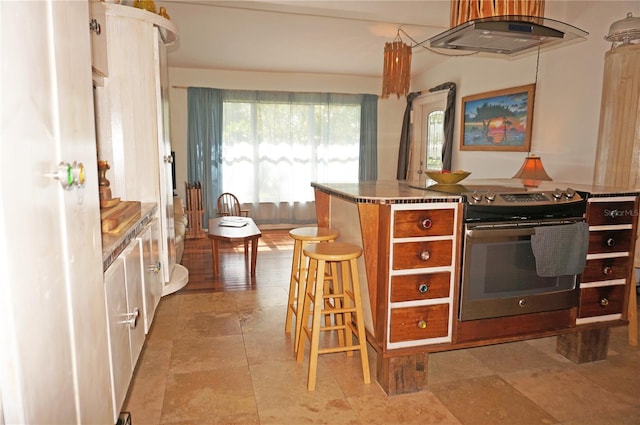 kitchen featuring stainless steel stove and a breakfast bar area