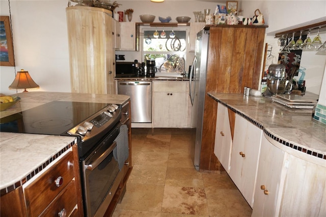 107 Dunn Dr NE, Port Charlotte, FL 33952 - kitchen featuring stainless steel appliances, a sink, and light stone counters