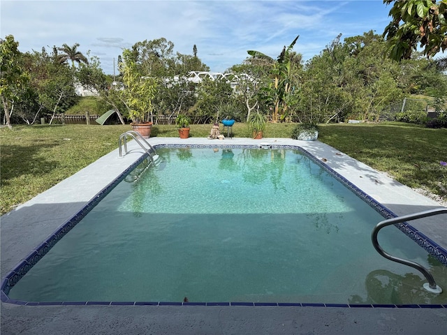 view of swimming pool featuring a lawn