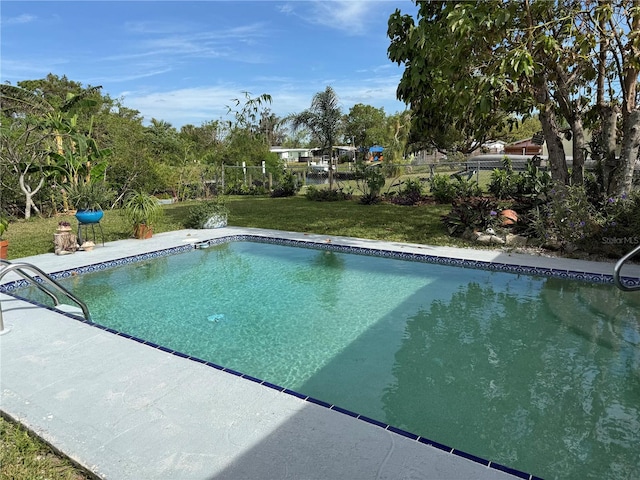 view of pool featuring a patio area and a yard