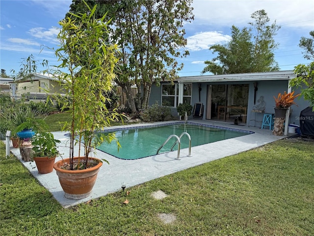 view of pool with a lawn