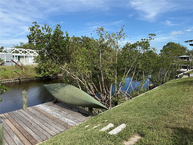 dock area featuring a water view and a yard