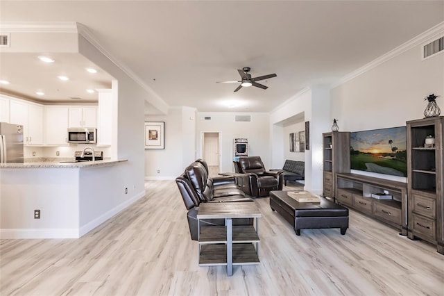 living room featuring light hardwood / wood-style flooring, ceiling fan, and ornamental molding