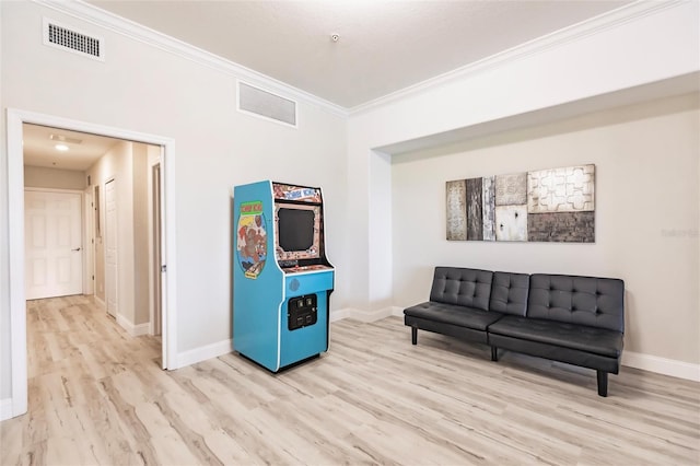 living area with crown molding and light wood-type flooring